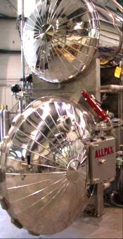 For rotary processes, a cage is mounted in the lower (process) vessel. The upper vessel is a hot water reservoir that is preheated for the next process and is used to capture the sterile water from the previous process.